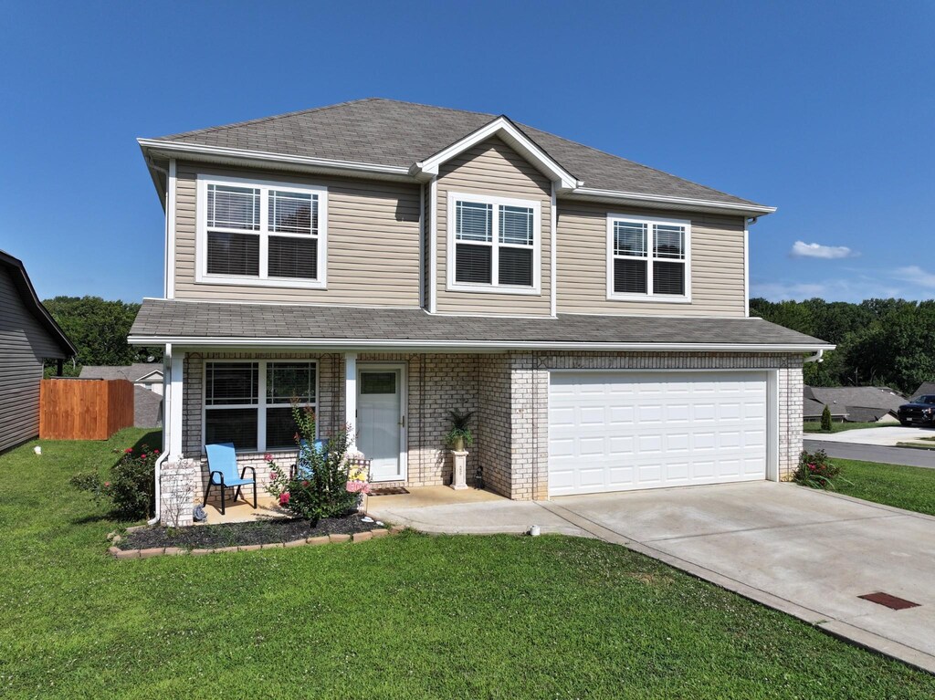 454 Golf Club Ln, Springfield, TN 37172 - view of front facade featuring covered porch, fence, a front lawn, an attached garage, and concrete driveway