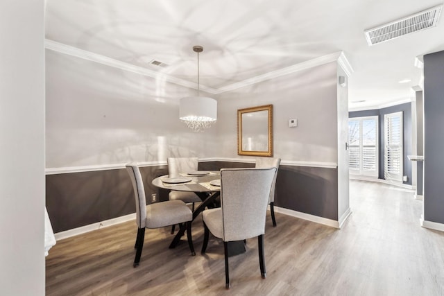 dining space featuring crown molding and hardwood / wood-style floors