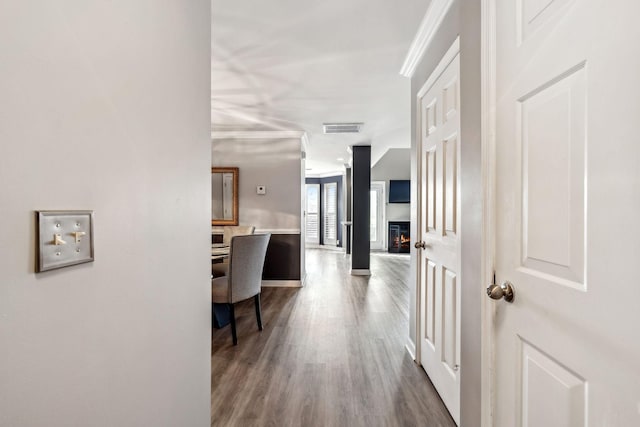 hall featuring hardwood / wood-style flooring and crown molding