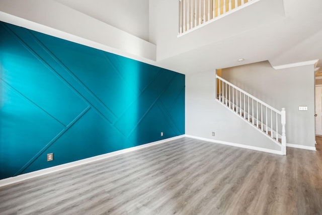 unfurnished living room featuring wood-type flooring and a high ceiling