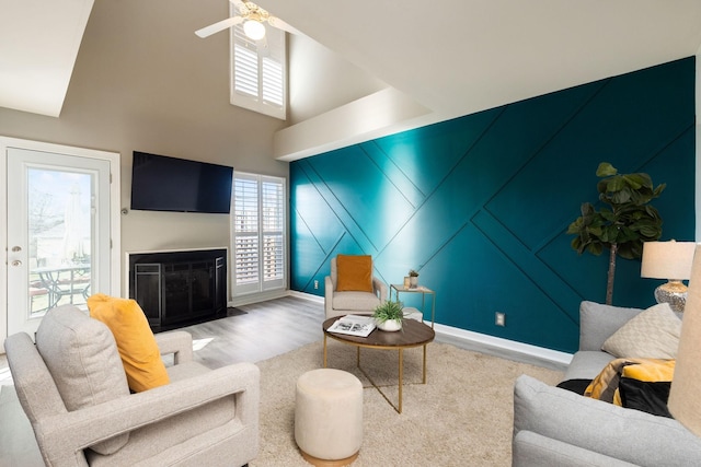 living room featuring ceiling fan, hardwood / wood-style floors, and a high ceiling