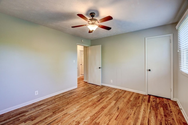 unfurnished bedroom featuring multiple windows, a textured ceiling, light hardwood / wood-style flooring, and ceiling fan