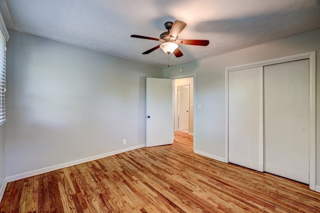 unfurnished bedroom featuring ceiling fan, light wood-type flooring, a textured ceiling, and a closet