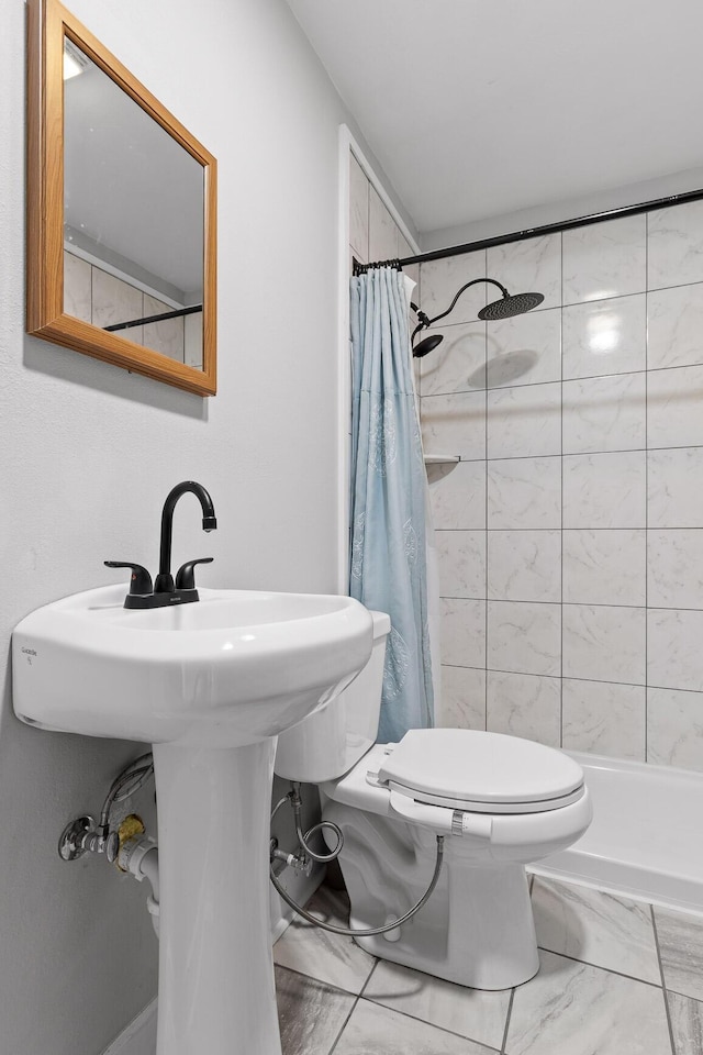 bathroom with a shower with curtain, toilet, and sink