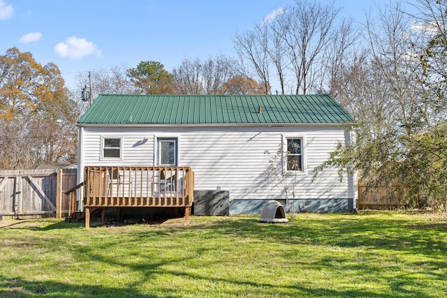 back of house with a wooden deck and a lawn