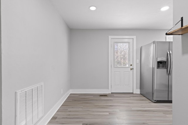 kitchen featuring stainless steel fridge and light hardwood / wood-style floors