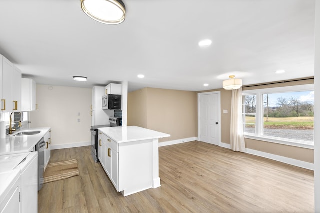 kitchen featuring a center island, sink, light hardwood / wood-style flooring, white cabinetry, and stainless steel appliances