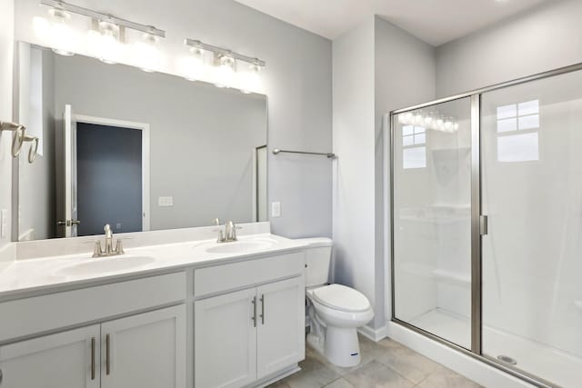 bathroom featuring tile patterned floors, vanity, toilet, and walk in shower