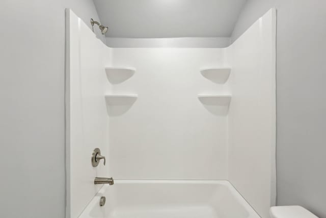 bathroom with toilet and bathing tub / shower combination