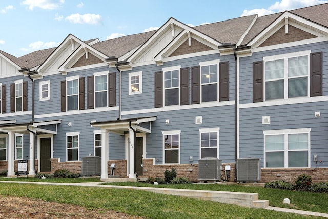 view of front of home with cooling unit and a front lawn