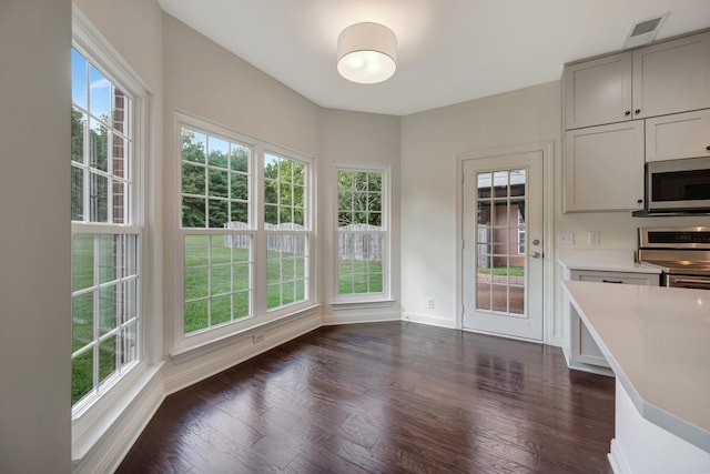 unfurnished dining area featuring dark wood-type flooring