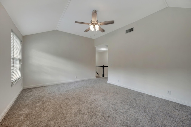 carpeted empty room with ceiling fan and lofted ceiling