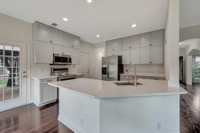 kitchen featuring appliances with stainless steel finishes, an island with sink, and sink