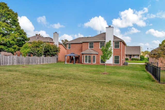 back of house with a gazebo and a lawn