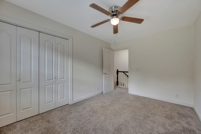 unfurnished bedroom with a closet, ceiling fan, and light colored carpet