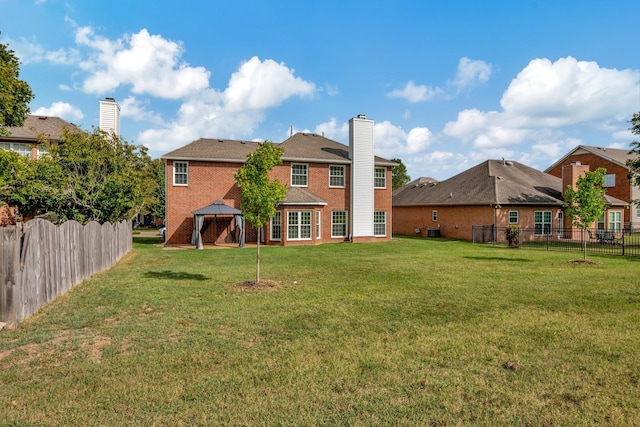 back of property with a gazebo and a yard