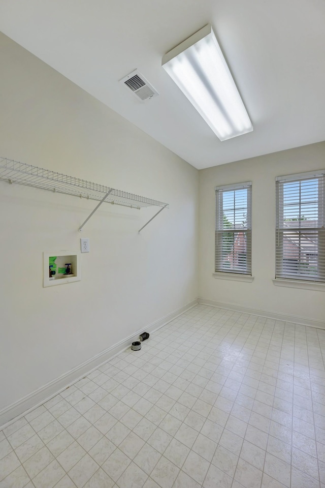 clothes washing area featuring washer hookup and light tile patterned floors