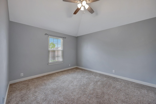 carpeted spare room with ceiling fan and vaulted ceiling