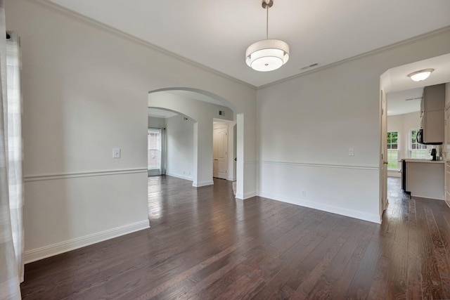 empty room featuring dark hardwood / wood-style flooring and ornamental molding