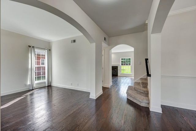 unfurnished room featuring crown molding and dark wood-type flooring