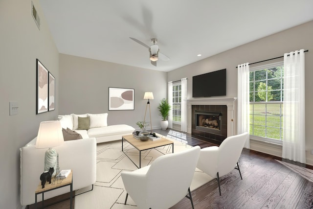 living room featuring ceiling fan, a fireplace, and hardwood / wood-style flooring