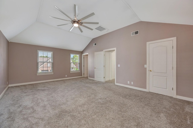 carpeted spare room featuring vaulted ceiling and ceiling fan