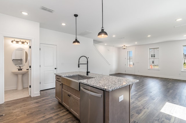 kitchen featuring light stone countertops, a kitchen island with sink, sink, pendant lighting, and dishwasher