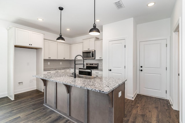 kitchen featuring sink, light stone counters, pendant lighting, white cabinets, and appliances with stainless steel finishes