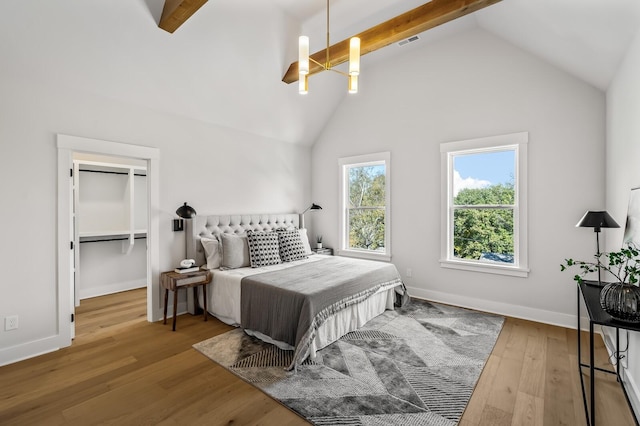 bedroom with an inviting chandelier, beamed ceiling, high vaulted ceiling, and hardwood / wood-style flooring