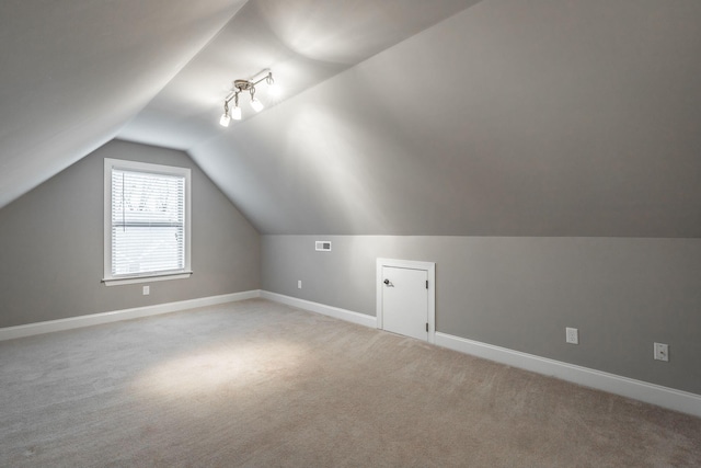 bonus room featuring light colored carpet and lofted ceiling