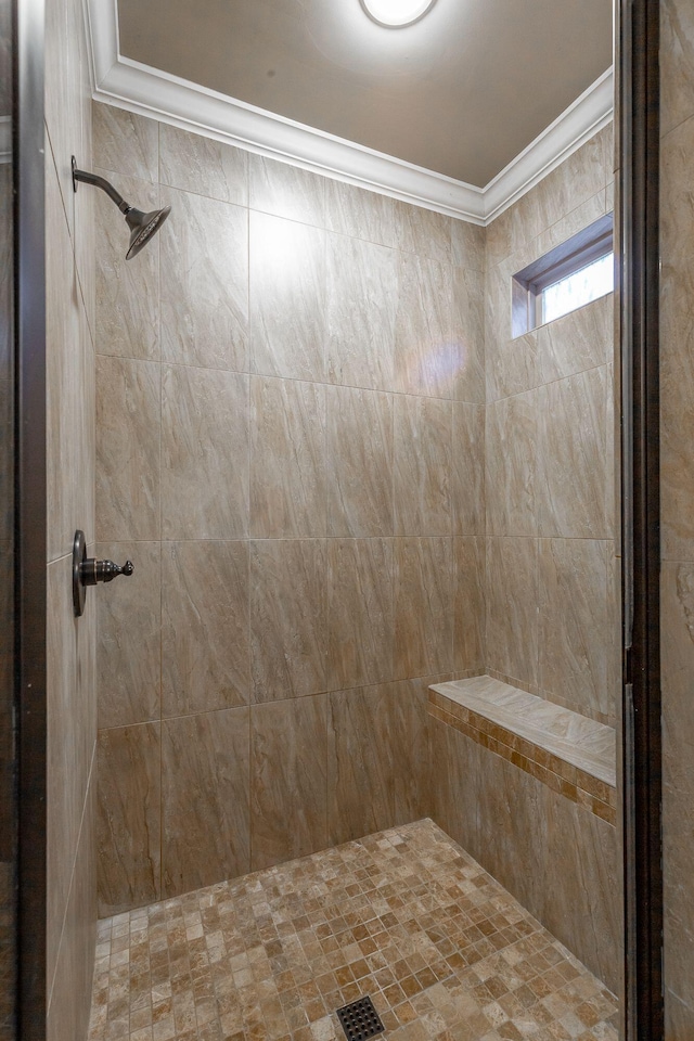 bathroom featuring a tile shower and ornamental molding