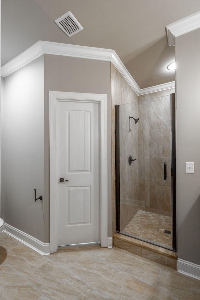 bathroom with toilet, an enclosed shower, and crown molding