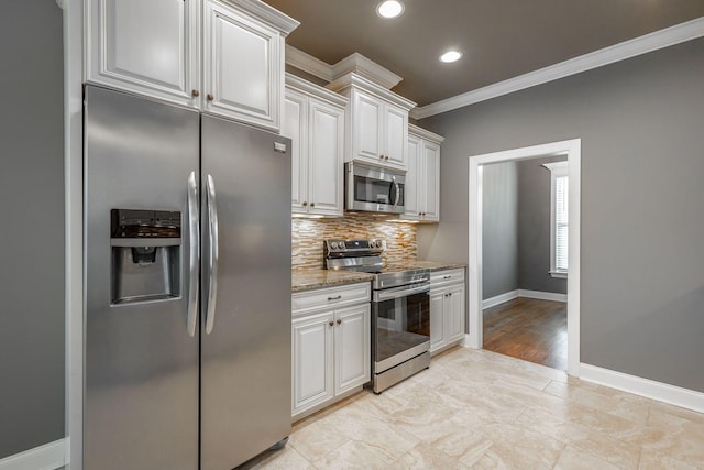 kitchen featuring stainless steel appliances, white cabinetry, and light stone counters