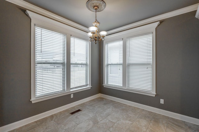 empty room featuring an inviting chandelier and crown molding