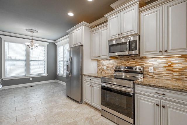 kitchen with light stone countertops, appliances with stainless steel finishes, a chandelier, and ornamental molding