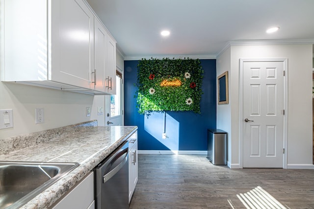 kitchen with stainless steel dishwasher, white cabinets, crown molding, and hardwood / wood-style floors