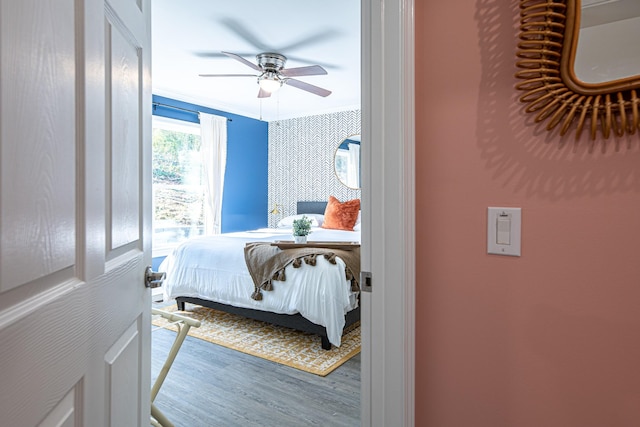 bedroom with ceiling fan, hardwood / wood-style floors, and crown molding