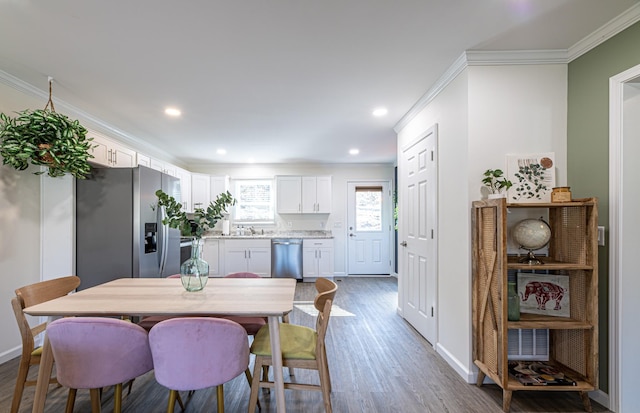 dining room featuring dark wood-type flooring, sink, and crown molding