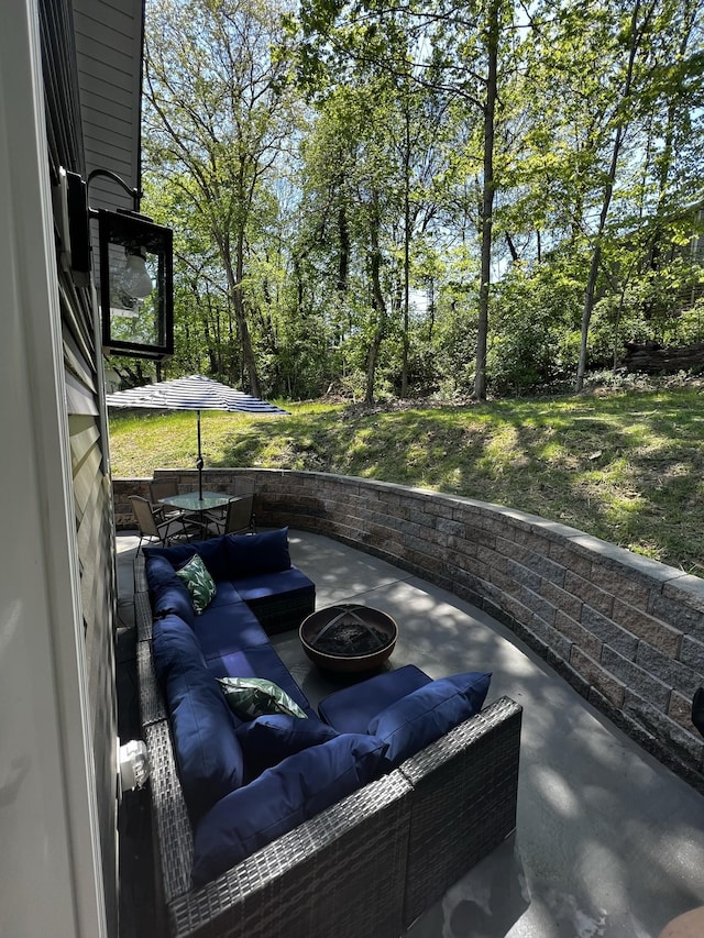 view of patio with an outdoor living space with a fire pit
