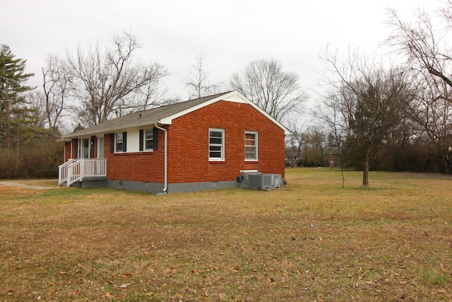 view of side of property with a yard and central AC unit