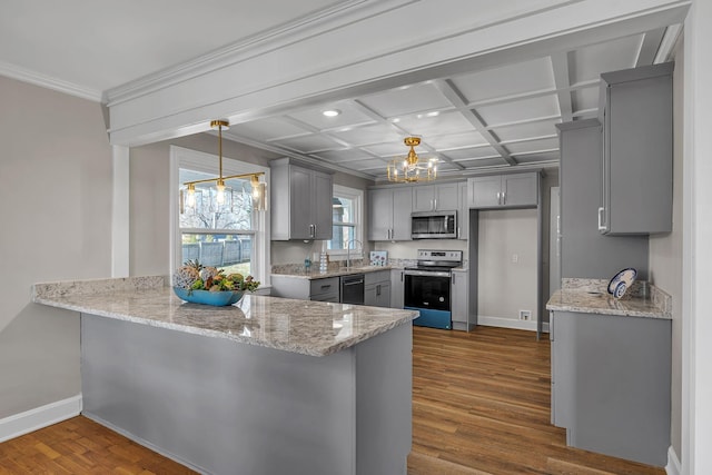 kitchen with gray cabinetry, coffered ceiling, hanging light fixtures, dark hardwood / wood-style flooring, and stainless steel appliances