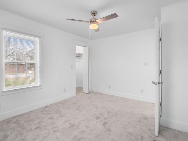 spare room featuring ceiling fan and light colored carpet