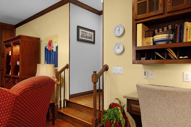 staircase with hardwood / wood-style floors and ornamental molding