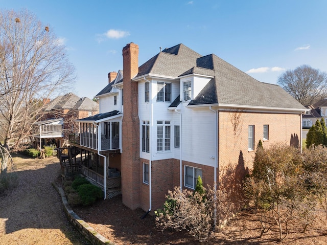 view of side of property with a sunroom and a deck