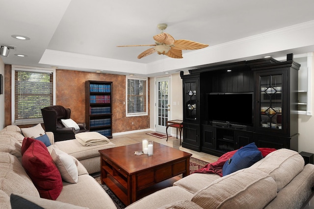 living room with ceiling fan, light tile patterned floors, crown molding, and a tray ceiling