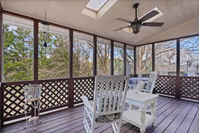 sunroom featuring lofted ceiling with skylight, a wealth of natural light, and ceiling fan