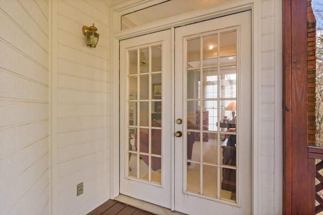 doorway to outside with french doors, hardwood / wood-style flooring, and wood walls