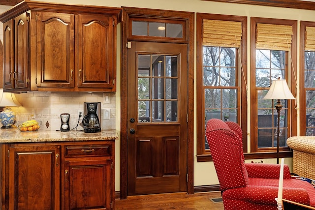 kitchen with light stone countertops, tasteful backsplash, and hardwood / wood-style flooring