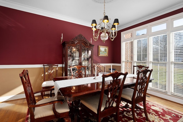 dining area featuring ornamental molding, plenty of natural light, a notable chandelier, and hardwood / wood-style floors