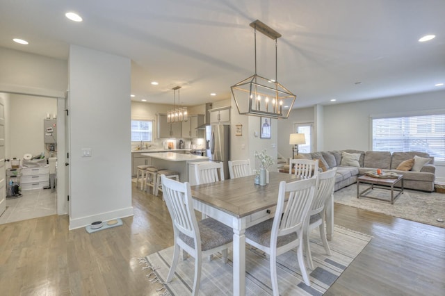 dining room featuring light hardwood / wood-style flooring, plenty of natural light, water heater, and sink